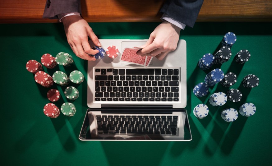 Man playing poker with laptop and chips